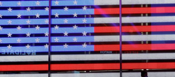 People stand next to a screen displaying a U.S. flag in Times Square during the 2020 U.S. presidential election in New York City, New York, U.S. November 4, 2020. - Sputnik International