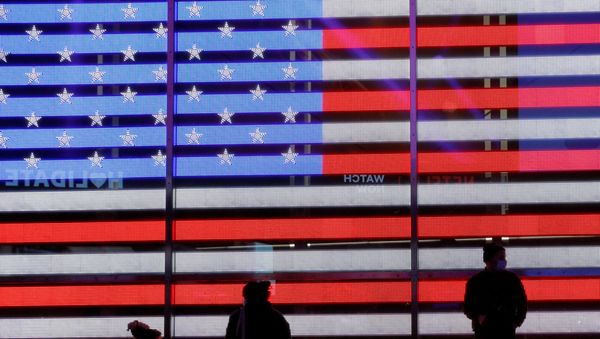 People stand next to a screen displaying a U.S. flag in Times Square during the 2020 U.S. presidential election in New York City, New York, U.S. November 4, 2020. - Sputnik International