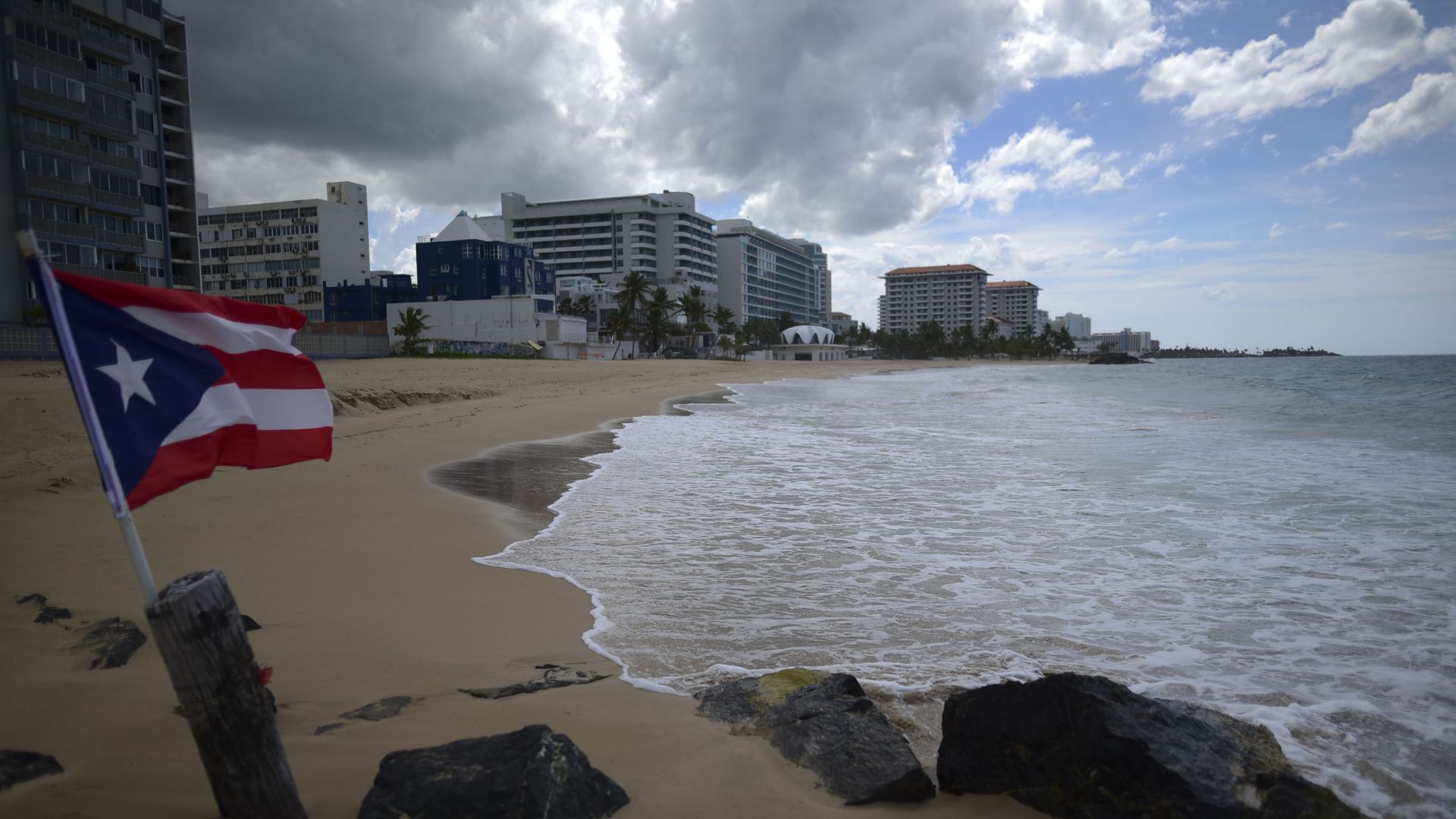 A Puerto Rican flag flies on an empty beach at Ocean Park, in San Juan, Puerto Rico, Thursday, May 21, 2020. Puerto Rico is cautiously reopening beaches, restaurants, churches, malls, and hair salons under strict conditions as the U.S. territory emerges from a two-month lockdown despite dozens of new coronavirus cases reported daily. A Puerto Rican flag flies on an empty beach at Ocean Park, in San Juan, Puerto Rico, Thursday, May 21, 2020. Puerto Rico is cautiously reopening beaches, restaurants, churches, malls, and hair salons under strict conditions as the U.S. territory emerges from a two-month lockdown despite dozens of new coronavirus cases reported daily. - Sputnik International, 1920, 03.03.2021