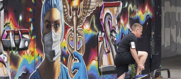 A runner pauses next to a mural showing medical images in the Shoreditch area of east London, following the introduction of measures to bring England out of the coronavirus lockdown, Thursday June 4, 2020 - Sputnik International