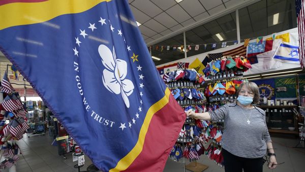 Shopkeeper Brenda McIntyre shows off the new Mississippi state flag - Sputnik International