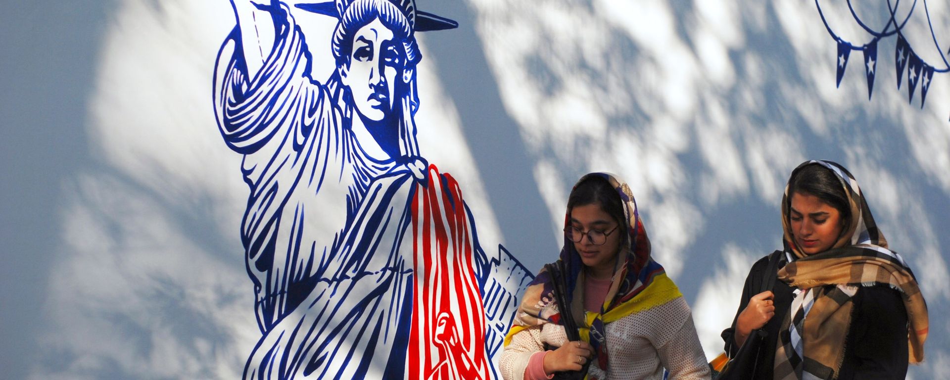 Women walk by mural on walls of former US Embassy compound in Tehran. File photo. - Sputnik International, 1920, 16.10.2022