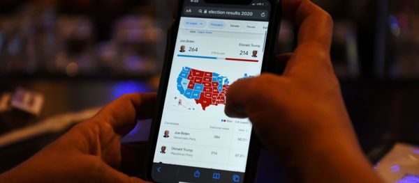 A woman uses her mobile phone to check the election results as Joe Biden’s lead increases, in Houston, Texas, U.S., November 6, 2020.  - Sputnik International