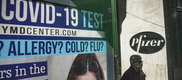 A bus stop ad for COVID-19 testing is shown outside Pfizer world headquarters in New York on Monday Nov. 9, 2020. Pfizer says an early peek at its vaccine data suggests the shots may be 90% effective at preventing COVID-19, but it doesn't mean a vaccine is imminent. - Sputnik International