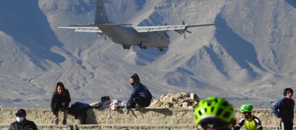 An Indian Air Force aircraft flies past cyclists near a mountain range in Leh, the joint capital of the union territory of Ladakh bordering China, on October 27, 2020 - Sputnik International