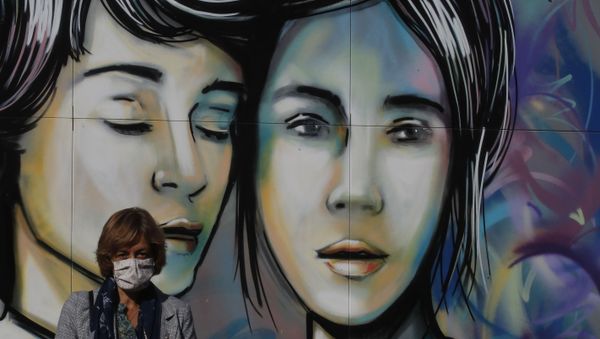 A woman wearing a face mask to help curb the spread of COVID-19 walks past a mural at Rome's Testaccio neighborhood, Wednesday, Nov. 11, 2020. A woman wearing a face mask to help curb the spread of COVID-19 walks past a mural at Rome's Testaccio neighborhood, Wednesday, Nov. 11, 2020. - Sputnik International