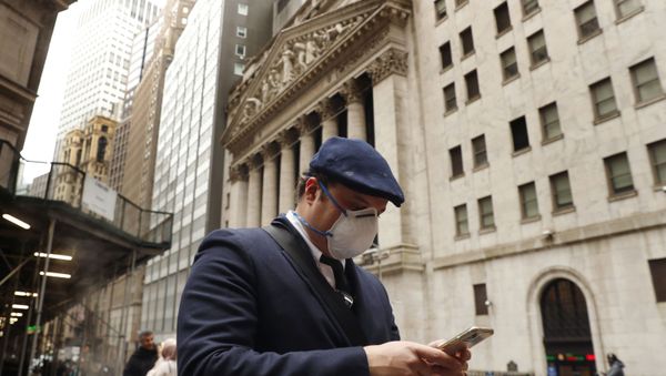 A man wears a protective mask as he walks past the New York Stock Exchange on the corner of Wall and Broad streets during the coronavirus outbreak in New York City, New York, U.S., March 13, 2020 - Sputnik International
