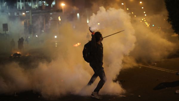 A protester returns a tear gas canister launched by police to disperse protesters who are trying to march to Congress in a demonstration against the removal of President Martin Vizcarra, in Lima, Peru, Thursday, Nov. 12, 2020. - Sputnik International