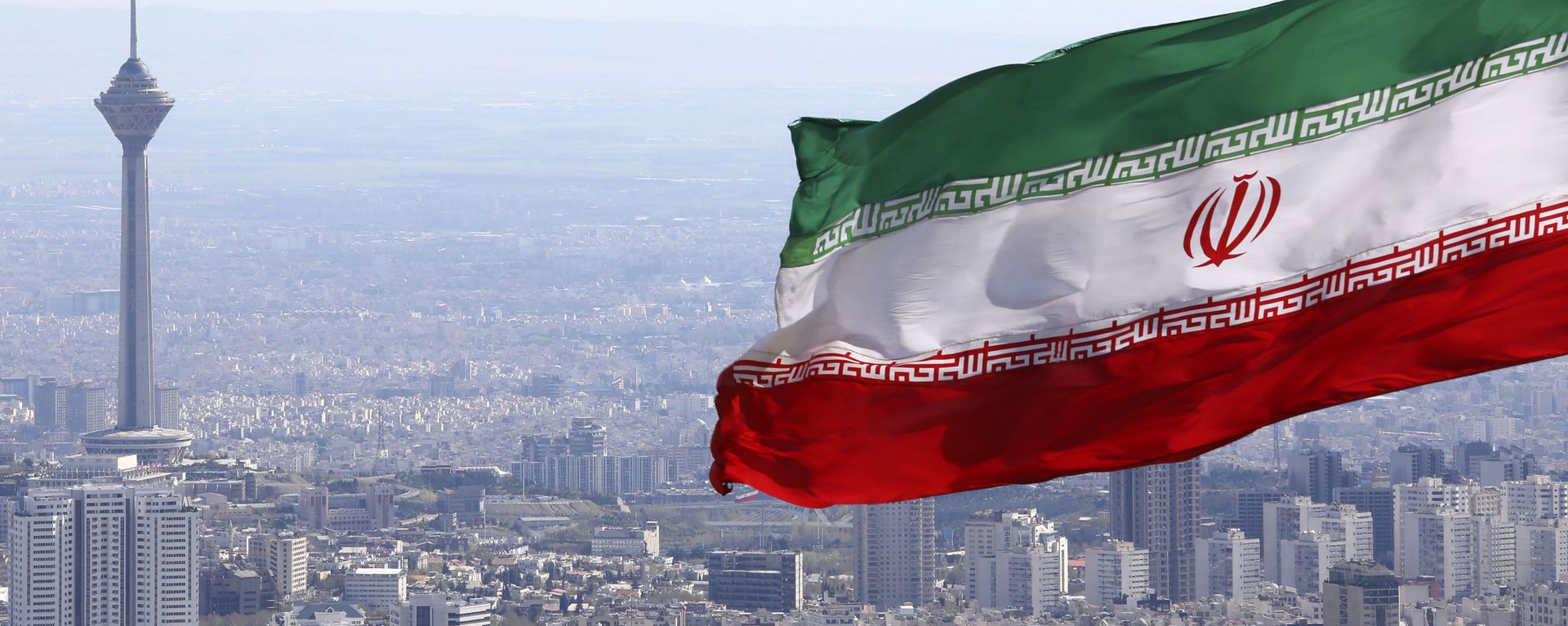 In this March 31, 2020, file photo, Iran's national flag waves as Milad telecommunications tower and buildings are seen in Tehran, Iran In this March 31, 2020, file photo, Iran's national flag waves as Milad telecommunications tower and buildings are seen in Tehran, Iran - Sputnik International, 1920, 07.02.2022