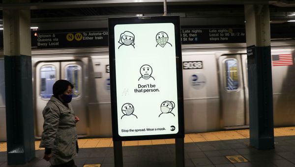 A subway rider wearing a mask passes a city-sponsored ad promoting face masks as a precautionary measure, as the global outbreak of the coronavirus disease (COVID-19) continues, in New York City, U.S., November 14, 2020. - Sputnik International