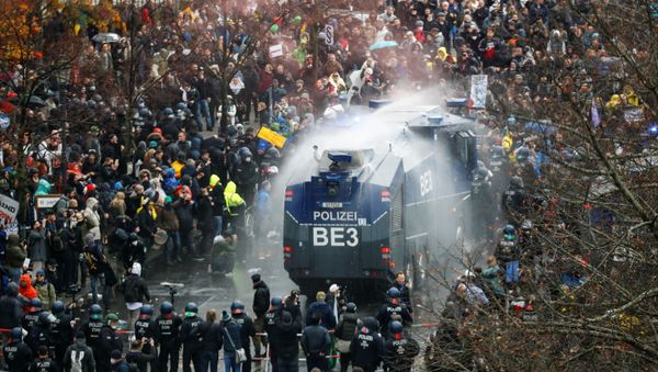 A general view of a protest against the government's coronavirus disease (COVID-19) restrictions, while police use water cannons, near the Reichstag, the seat of Germany's lower house of parliament Bundestag, in Berlin, November 18, 2020 - Sputnik International