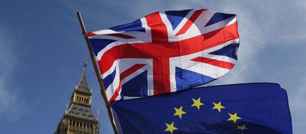 In this file picture, taken on 25 March 2017, an EU flag and a Union flag held by a demonstrator is seen with Elizabeth Tower (Big Ben) and the Houses of Parliament as marchers taking part in an anti-Brexit, pro-European Union (EU) enter Parliament Square in central London. - Sputnik International