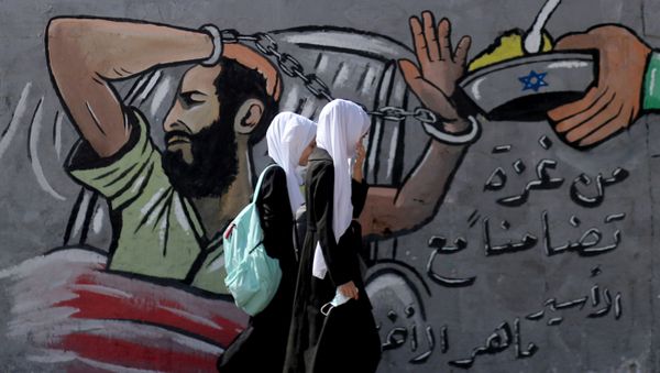FILE PHOTO: Palestinian students walk past a mural depicting hunger-striking Palestinian prisoner Maher Al-Akhras, who is held by Israel, in the central Gaza Strip, 19 October 2020 FILE PHOTO: Palestinian students walk past a mural depicting hunger-striking Palestinian prisoner Maher Al-Akhras, who is held by Israel, in the central Gaza Strip, 19 October 2020 - Sputnik International
