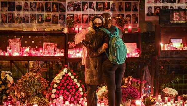 Two young women grieve for those who died at the Colectiv nightclub in Bucharest in 2015. - Sputnik International