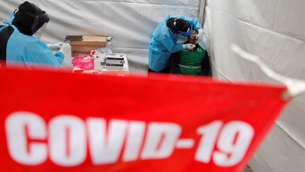A healthcare worker wearing personal protective equipment (PPE) takes a swab sample from a man to be quick result tested for the coronavirus disease (COVID-19) in Mexico City, Mexico November 20, 2020 A healthcare worker wearing personal protective equipment (PPE) takes a swab sample from a man to be quick result tested for the coronavirus disease (COVID-19) in Mexico City, Mexico November 20, 2020 - Sputnik International