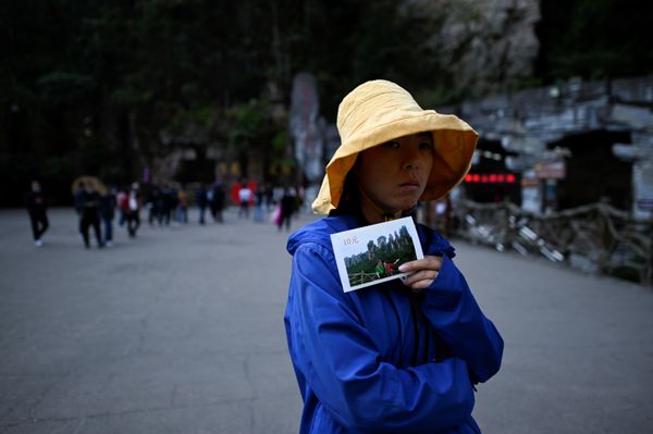 A vendor waits for tourists to take travel photos at the entrance of the Bailong Elevator in Zhangjiajie National Forest Park, China's Hunan province. - Sputnik International