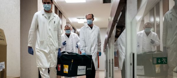 In this handout photo released by the Hungarian Foreign Ministry, laboratory assistants carry a bag with Russia's coronavirus vaccine Gam-COVID-Vac, trade-named Sputnik V inside, in Budapest, Hungary. In this handout photo released by the Hungarian Foreign Ministry, laboratory assistants carry a bag with Russia's coronavirus vaccine Gam-COVID-Vac, trade-named Sputnik V inside, in Budapest, Hungary. - Sputnik International