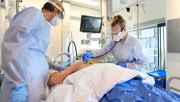 Members of the medical personnel wearing full protective suits examine a patient infected with the coronavirus disease (COVID-19), in the intensive care unit at Maastricht UMC+ Hospital in Maastricht, Netherlands, November 10, 2020. - Sputnik International