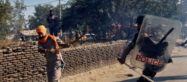 A policeman chases away a farmer during a protest against the newly passed farm bills at Singhu border near Delhi, India A policeman chases away a farmer during a protest against the newly passed farm bills at Singhu border near Delhi, India - Sputnik International