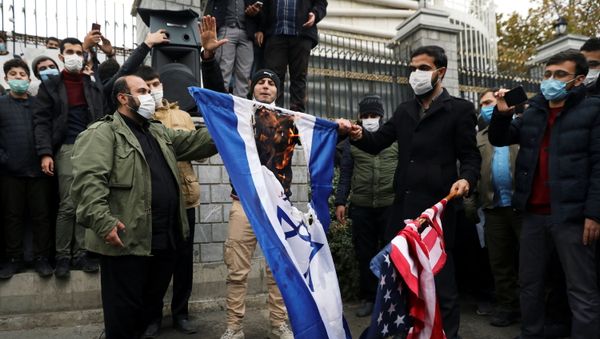 Protesters burn the U.S. and Israeli flags during a demonstration against the the killing of Mohsen Fakhrizadeh, Iran's top nuclear scientist, in Tehran, Iran, November 28, 2020.  - Sputnik International