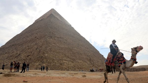 A camel guide waits for customers next to the pyramid of Khafre or Chefren at the Giza pyramids plateau in Giza, Egypt 15 November 2020. - Sputnik International