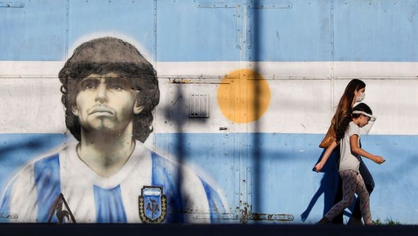 People walk past graffiti of soccer legend Diego Armando Maradona in Buenos Aires, Argentina, 27 November 2020. - Sputnik International