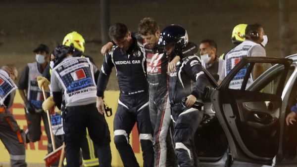 Formula One F1 - Bahrain Grand Prix - Bahrain International Circuit, Sakhir, Bahrain - November 29, 2020 Haas' Romain Grosjean walks away from the crash scene with the help of medical officers after crashing out of the race. Pool via REUTERS/Hamad I Mohammed - Sputnik International