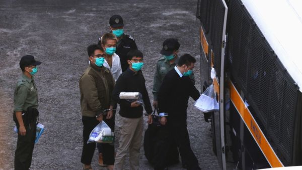 Pro-democracy activists Ivan Lam and Joshua Wong walk to a prison van to head to court, after pleading guilty to charges of organising and inciting an unauthorised assembly near the police headquarters during last year's anti-government protests, in Hong Kong, China December 2, 2020 - Sputnik International