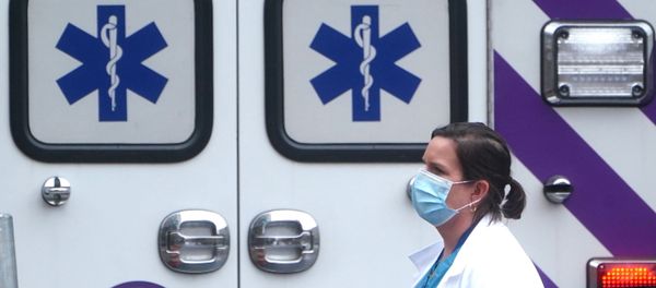 A health care professional walks past an ambulance during the coronavirus disease (COVID-19) pandemic in the Manhattan borough of New York City, New York, U.S., November 13, 2020 - Sputnik International
