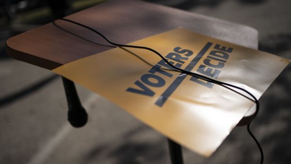 A sign that reads Voters Decide is placed next to a hanging microphone as people gather at the Civic Center Park while waiting for the results of election, Wednesday, Nov. 4, 2020, in Kenosha, Wis. - Sputnik International