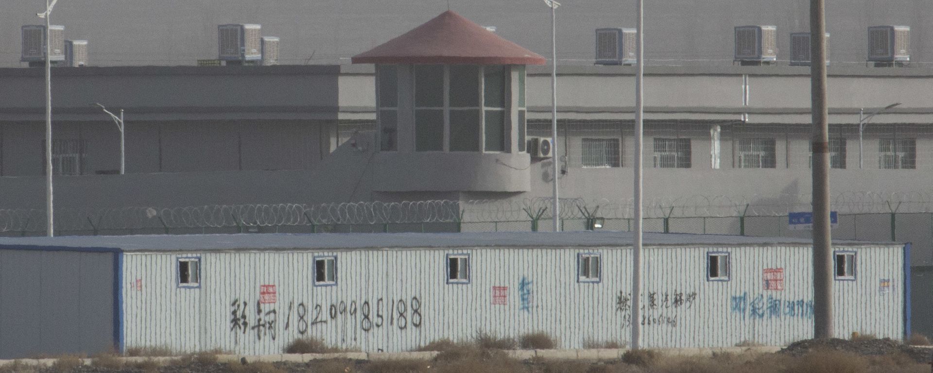 FILE - In this Monday, Dec. 3, 2018, file photo, a guard tower and barbed wire fences are seen around a facility in the Kunshan Industrial Park in Artux in western China's Xinjiang region. The U.S. Customd snd Border Protection on Wednesday said it will block imports from a major Chinese producer of cotton goods for its suspected use of workers detained as part of a crackdown on ethnic minorities in China's northwest - Sputnik International, 1920, 24.06.2021