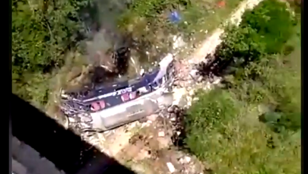A screenshot from the video showing the crashed bus lying on the ground beneath the bridge. December 4, 2020 - Sputnik International