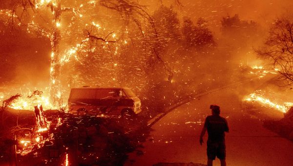 Bruce McDougal watches embers fly over his property as the Bond Fire burns through the Silverado community in Orange County, Calif., on Thursday, Dec. 3, 2020 - Sputnik International