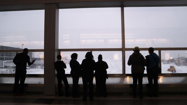 Stranded travelers and airport workers watch front loaders clear snow from the apron around Gates C and D at Terminal B at LaGuardia Airport, Thursday, Jan. 4, 2018, in New York. - Sputnik International
