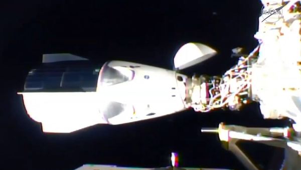 This NASA TV video grab shows Nasa's SpaceX Crew-1 mission aboard the SpaceX Crew Dragon (L) docked to the International Space Station (R) on 16 November 2020.  - Sputnik International
