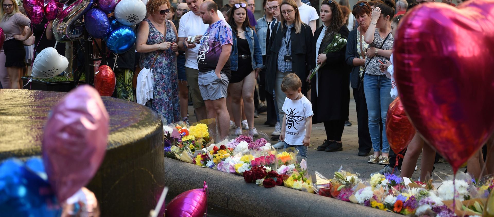 People pay their respects as they look at flowers and balloons left in central Manchester on May 22, 2018, the one year anniversary of the deadly attack at Manchester Arena. People pay their respects as they look at flowers and balloons left in central Manchester on May 22, 2018, the one year anniversary of the deadly attack at Manchester Arena. - Sputnik International, 1920, 07.12.2020