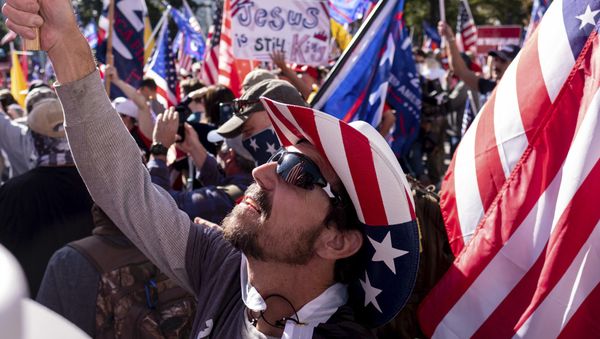 Rusty Albietz, of Blairsville, Ga., looks up at his flag while rallying with supporters of President Donald Trump outside of the Georgia State Capitol in Atlanta on Saturday, Nov. 21, 2020.  - Sputnik International