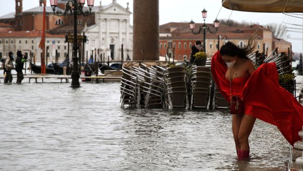 A model holding her dress on flooded St. Mark's Square, Venice - Sputnik International