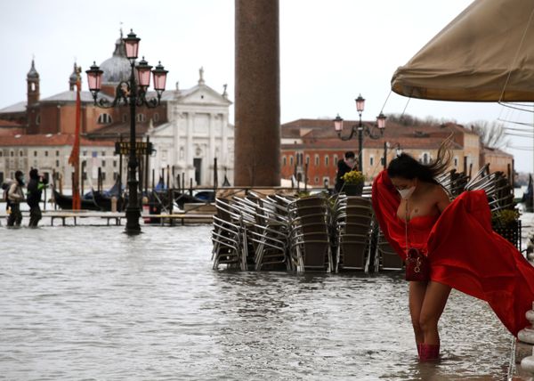 A model holding her dress on flooded St. Mark's Square, Venice A model holding her dress on flooded St. Mark's Square, Venice - Sputnik International