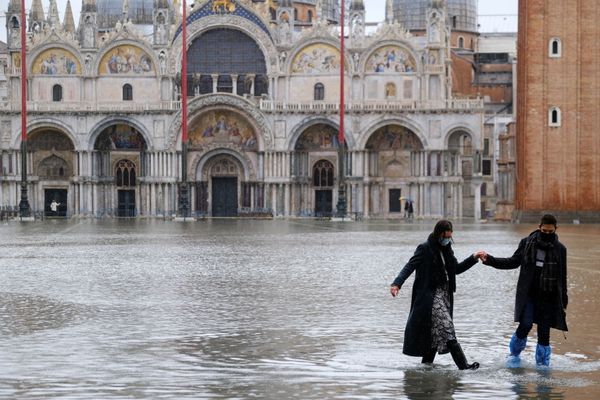 A couple walks in flooded St. Mark's Square, Venice A couple walks in flooded St. Mark's Square, Venice - Sputnik International