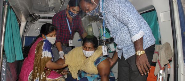 A patient is assisted by others to get down from an ambulance at the district government hospital in Eluru, Andhra Pradesh state, India, Tuesday, Dec.8, 2020 - Sputnik International