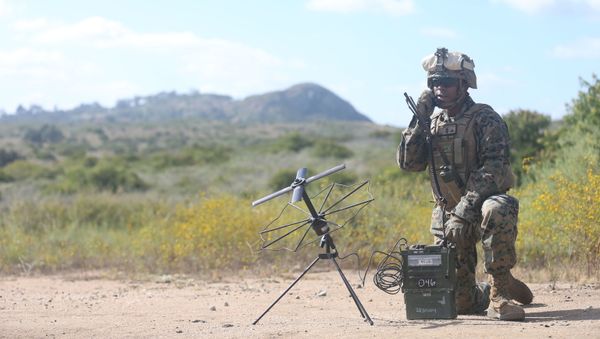 U.S. Marine Lance Cpl. Taj Stewart, a field radio operator with Communication Company, Headquarters Regiment, 1st Marine Logistics Group utilizes an Army-Navy Portable Radio Communication to send transmissions on Camp Pendleton, Calif., June 12, 2017. - Sputnik International