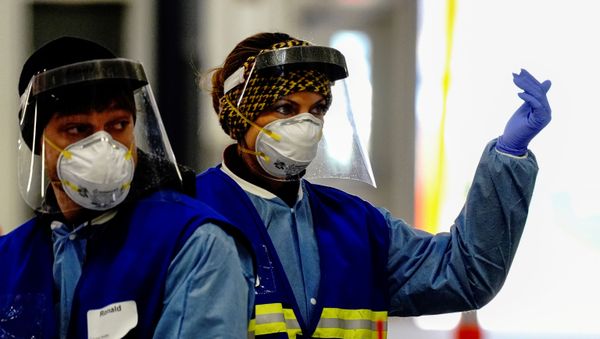 A healthcare worker beckons incoming cars at a drive-thru COVID-19 testing site inside the Alliant Energy Center complex, as the coronavirus disease (COVID-19) outbreak continues in Madison, Wisconsin, U.S., October 31, 2020. - Sputnik International