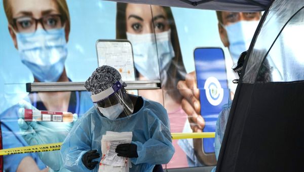 A health care employee works at a walk-up COVID-19 testing site, Wednesday, Nov. 18, 2020, in Miami - Sputnik International