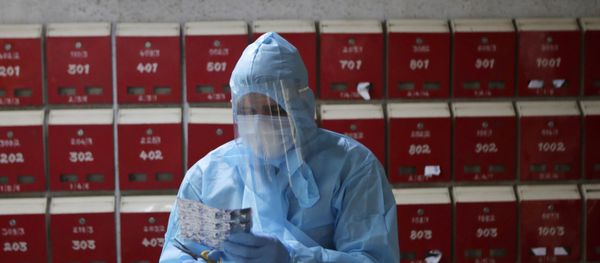 A doctor engages in screening of residents at an apartment complex for COVID-19 symptoms in Mumbai, India, Tuesday, July 28, 2020.  - Sputnik International