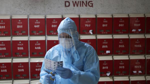 A doctor engages in screening of residents at an apartment complex for COVID-19 symptoms in Mumbai, India, Tuesday, July 28, 2020.  - Sputnik International