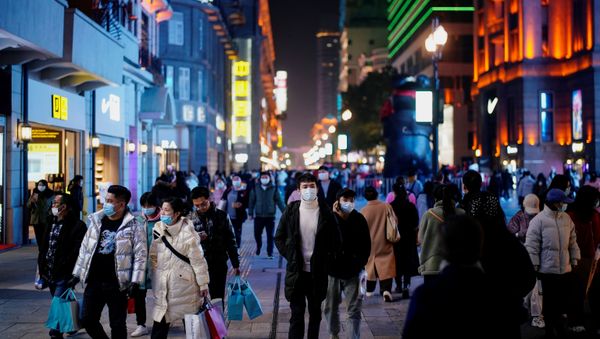 People wearing face masks are seen at a main shopping area almost a year after the global outbreak of the coronavirus disease (COVID-19) in Wuhan, Hubei province, China December 7, 2020. Picture taken December 7, 2020 - Sputnik International