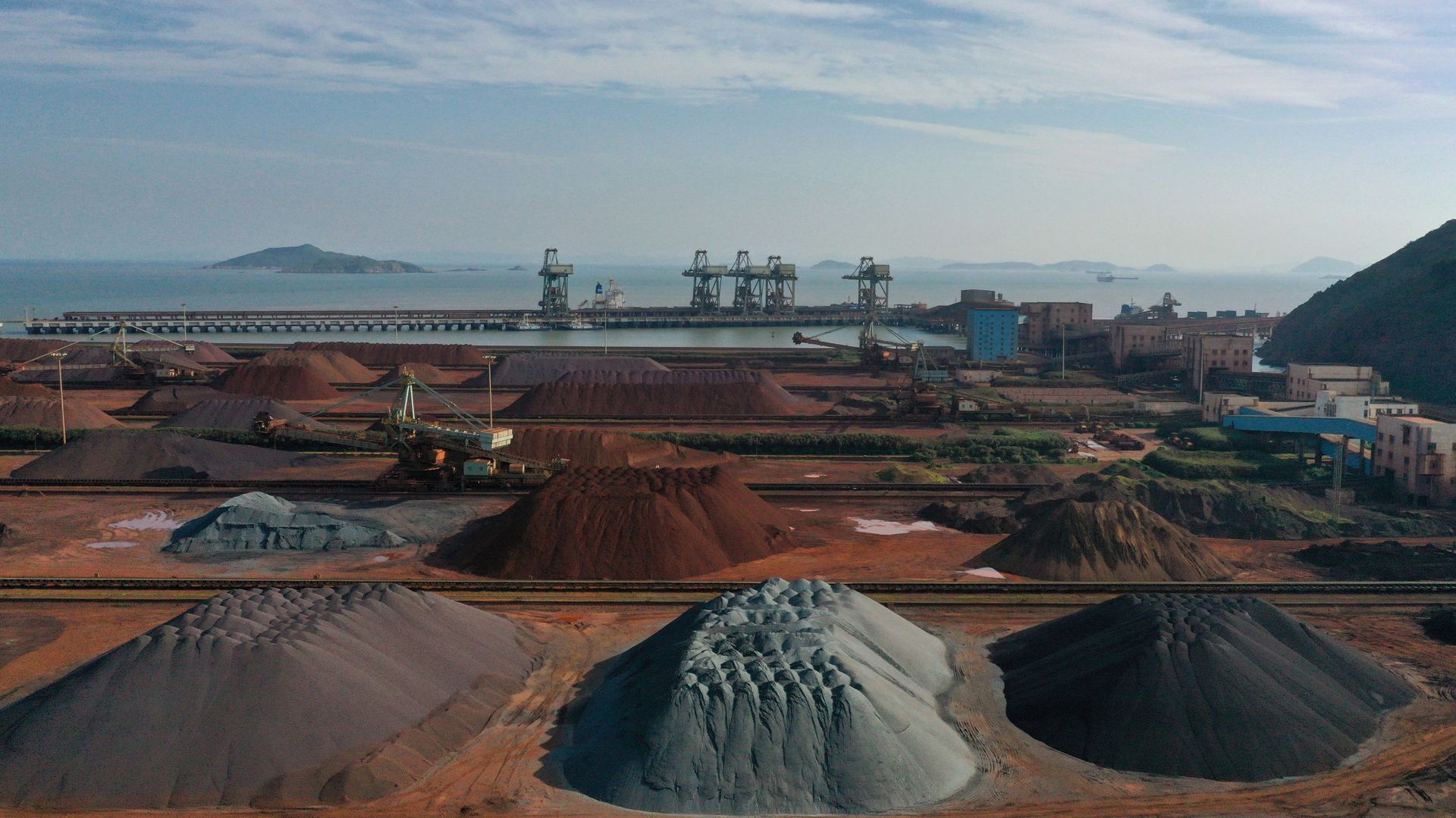 Piles of imported iron ore are seen at a port in Zhoushan in the eastern Chinese province of Zhejiang. - Sputnik International, 1920, 11.05.2021