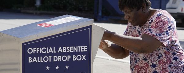 A voter drops their ballot off during early voting, Monday, Oct. 19, 2020, in Athens, Ga. With record turnout expected for this year's presidential election and fears about exposure to the coronavirus, election officials and advocacy groups have been encouraging people to vote early, either in person or by absentee ballot. (AP Photo/John Bazemore) - Sputnik International