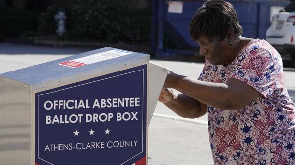 A voter drops their ballot off during early voting, Monday, Oct. 19, 2020, in Athens, Ga. With record turnout expected for this year's presidential election and fears about exposure to the coronavirus, election officials and advocacy groups have been encouraging people to vote early, either in person or by absentee ballot. (AP Photo/John Bazemore) - Sputnik International
